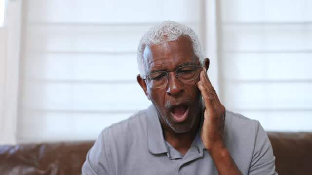 Senior black man with jaw pain or tooth pain