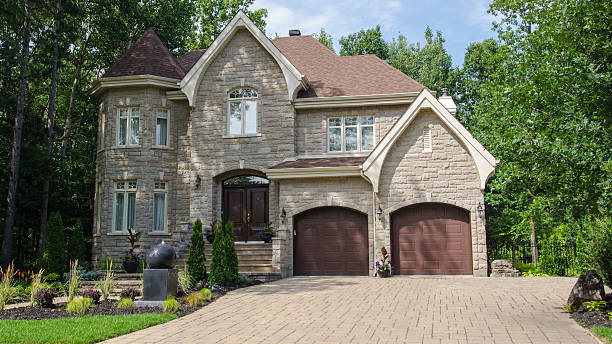 istock Trees behind a large beige stone house with two garages 176744139