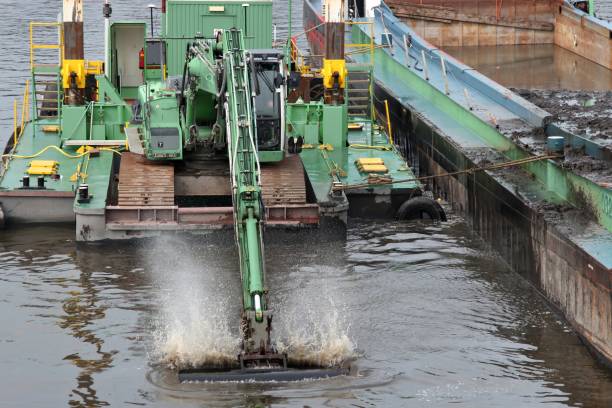 crawler excavator on floating pontoon deepening the fairway on a river