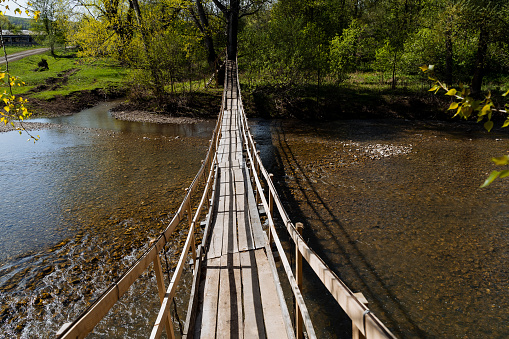 Wooden bridge across the river, panorama, landscape on the river, hinged crossing. Shallow river. sunny day, spring, summer. High quality photo