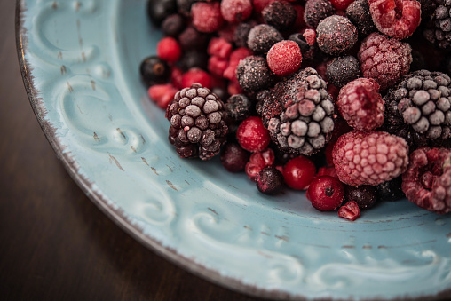 Mix of Frozen Berries Fruit on Blue Ceramic Plate - Close-up