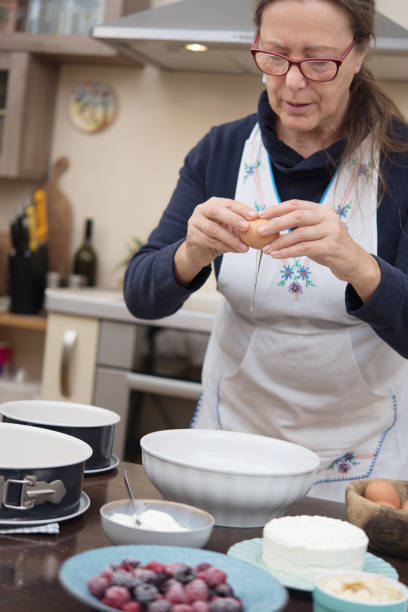 istock Mature Woman Breaking Eggs into Ceramic Bowl 1767465549