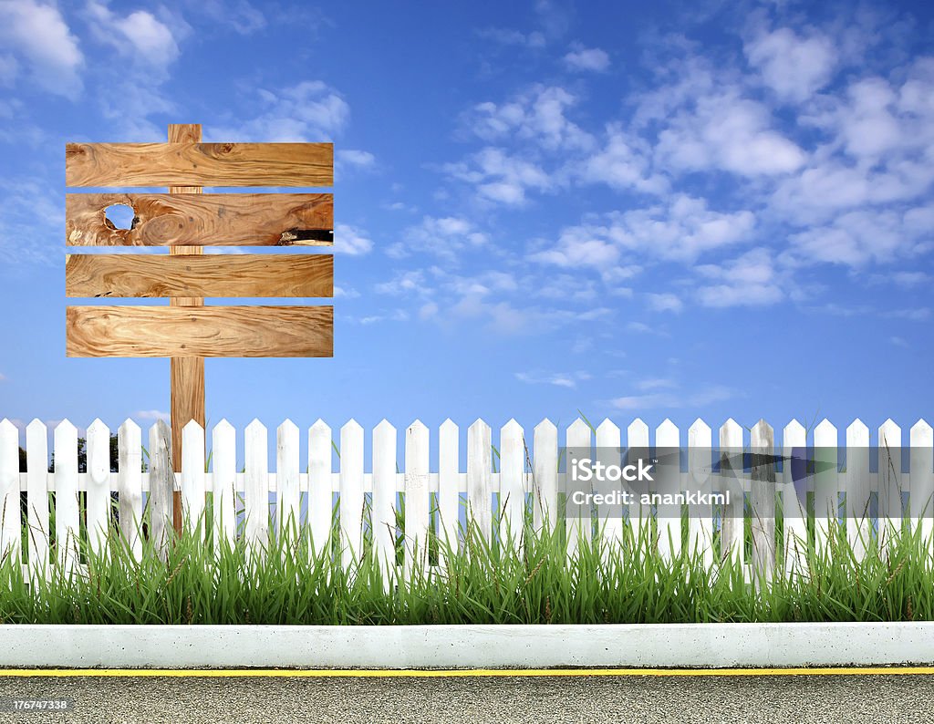 wooden signpost wooden signpost with white fence and blue sky Blank Stock Photo