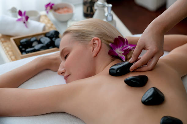 massagem com pedras quentes no salão de spa no resort de luxo. quiescente - lastone therapy massaging stone shiatsu - fotografias e filmes do acervo