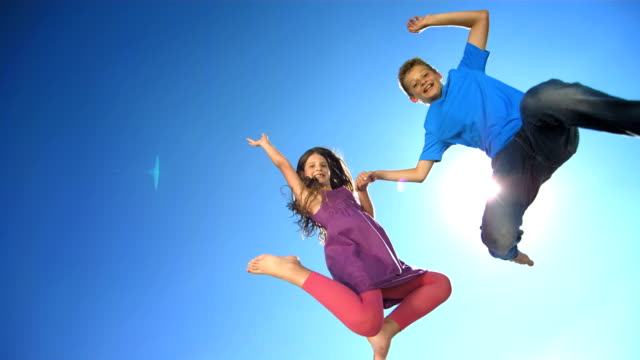 HD Super Slow-Mo: Happy Siblings Jumping In The Air