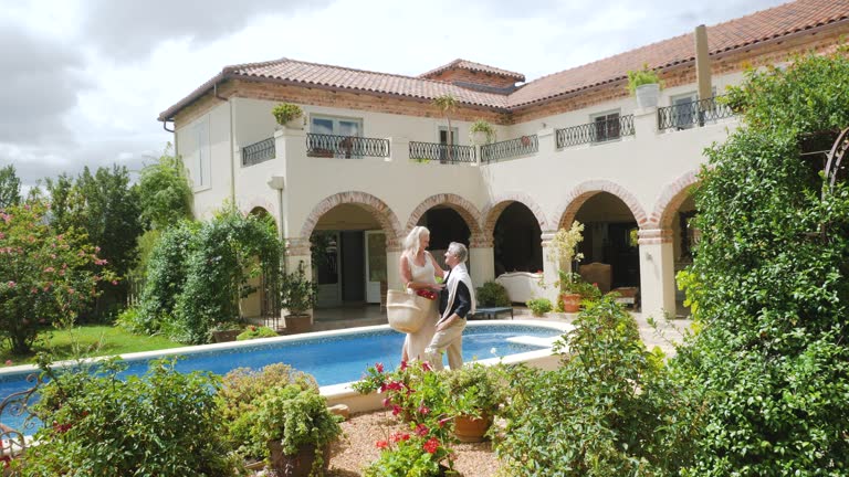 Senior couple hugging at sunny summer villa poolside