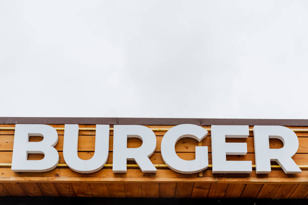 istock Burger restaurant logo, burger word sign in white letters, text written on a tree background, street restaurant, meat food, street food 1767493588