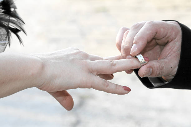 istock married couple holding hands with rings 176749729