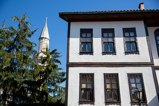 Historical white building with wooden window frames and a distinct minaret in the backdrop, representing Ottoman-era architecture in Taraklı, Sakarya, Turkey.