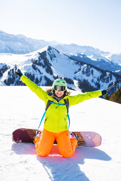 istock snowboarded girl posing on the snow with action camera. 1767523474