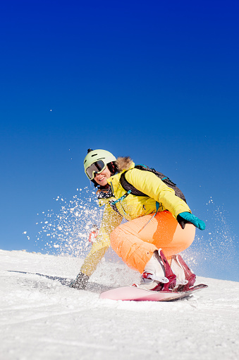 Vital senior, gray-haired men snow skier skiing, enjoying on sunny ski resorts. Skiing carving at high speed against blue sky.