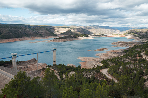 Landscape with clouds of the Tous reservoir with a low level in its waters in October 2023, Spain