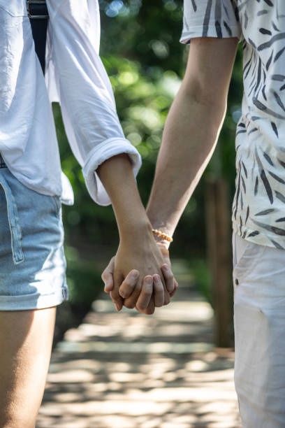 istock Couple holding hands walking across a bridge in the forest 1767578987