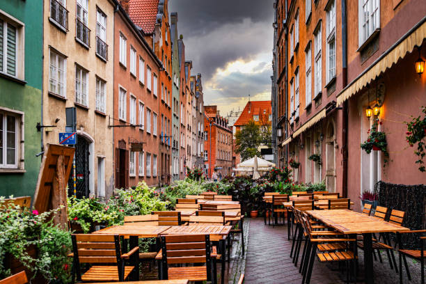 Rainy day in the autumn city in Europe. Medieval Gdansk Old Town in Gdansk. rainy weather in the historical district. Ancient medieval houses and empty sidewalk cafe rainy cafe stock pictures, royalty-free photos & images