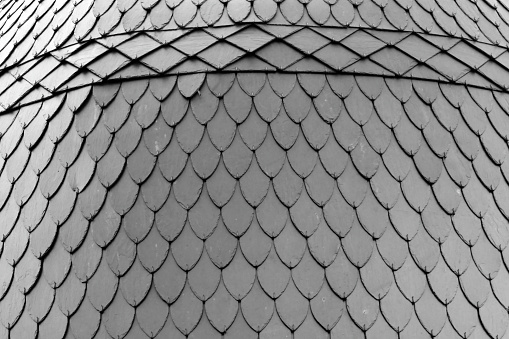 Monochrome close up of an intricately tiled slate roof in the town centre of Arcachon, France