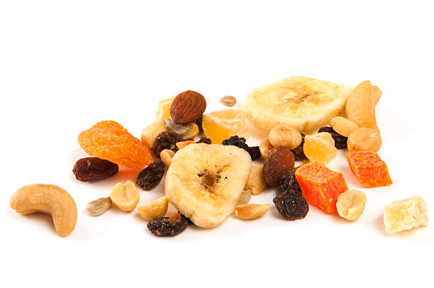 Assorted dried fruits and nuts on a white background Focus on dried fruit and nuts on white background dried fruit on white stock pictures, royalty-free photos & images