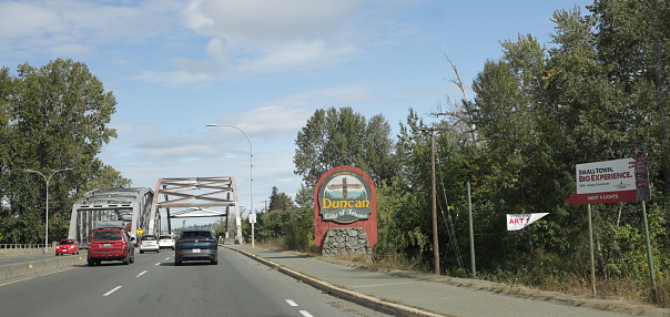 Duncan, Canada - September 17, 2023: The Trans-Canada Highway in Duncan continues on two bridges spanning the Cowichan River. Summer day with light clouds over the Cowichan Valley District on Vancouver Island.