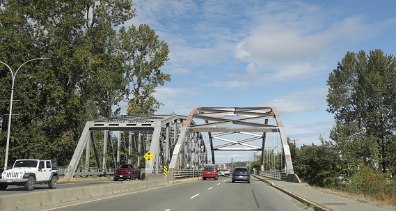 Duncan, Canada - September 17, 2023: Looking north on the Trans-Canada Highway to two bridges spanning the Cowichan River in the Cowichan Valley District. Summer day with light clouds.