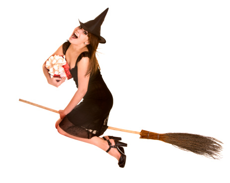 Halloween witch in black dress and hat fly on broom with red gift box.Isolated.