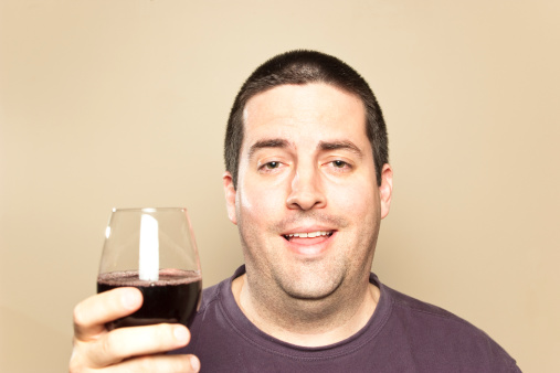 A stock photo of a man who has had a few drinks. Shot against a plain beige background