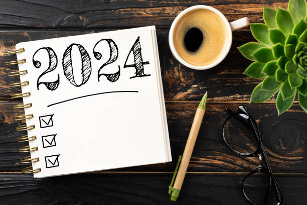 istock New year resolutions 2024 on desk. 2024 resolutions list with notebook, coffee cup on wooden table. Goals, resolutions, plan, action, checklist concept. New Year 2024 template 1767603958
