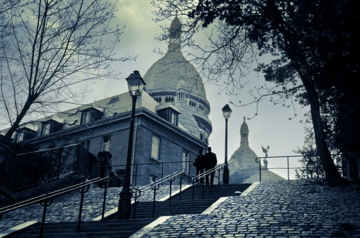 The Sacre Coeur in Montmartre and a couple walking down the stairs