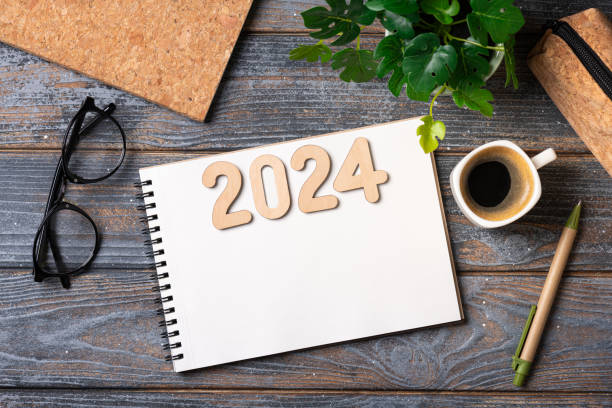 neujahrsvorsätze für 2024 auf dem schreibtisch. zielliste 2024 mit notizbuch, kaffeetasse, pflanze auf holztisch. vorsätze, plan, ziele, aktion, strategie, erfolg, ideenkonzept. vorsätze für das neue jahr 2024 - determination new years eve list aspirations stock-fotos und bilder