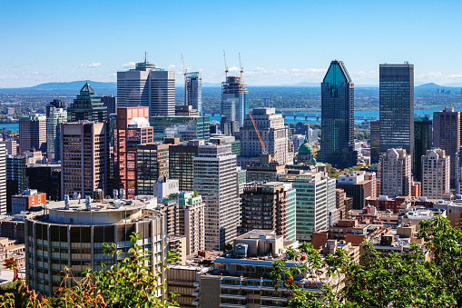 Beautiful sky and sunrise light over Montreal city in the morning time. Amazing view from Mont-Royal with colorful blue architecture. Stunning panorama of Montreal downtown skyline and business buildings.