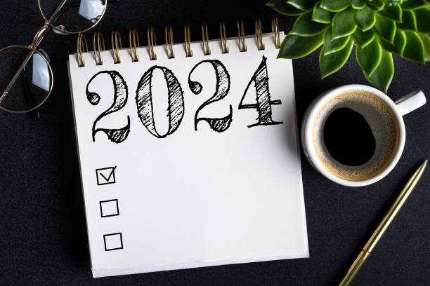 istock 2024 New year resolutions on desk. 2024 goals list with notebook, coffee cup, plant on black table. Resolutions, plan, goals, action, checklist, idea concept. New Year 2024 resolutions 1767607272