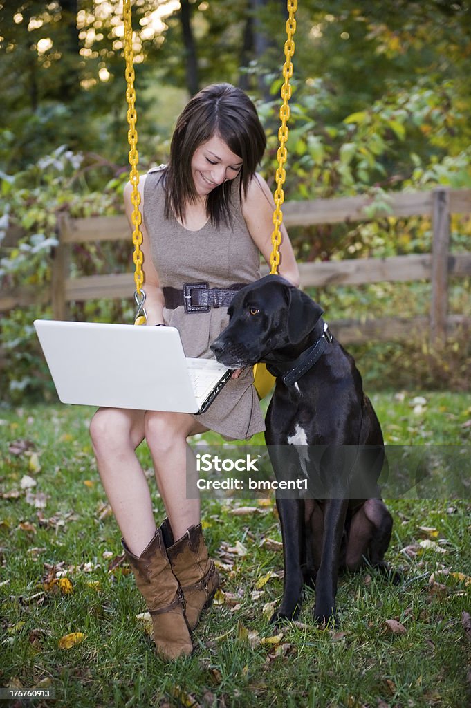 Giovane donna e cane vista computer portatile all'aperto - Foto stock royalty-free di Cane