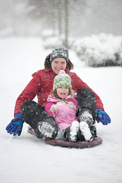 istock Mother and Daughter Sledding in Falling Snow (XXXL) 176761109