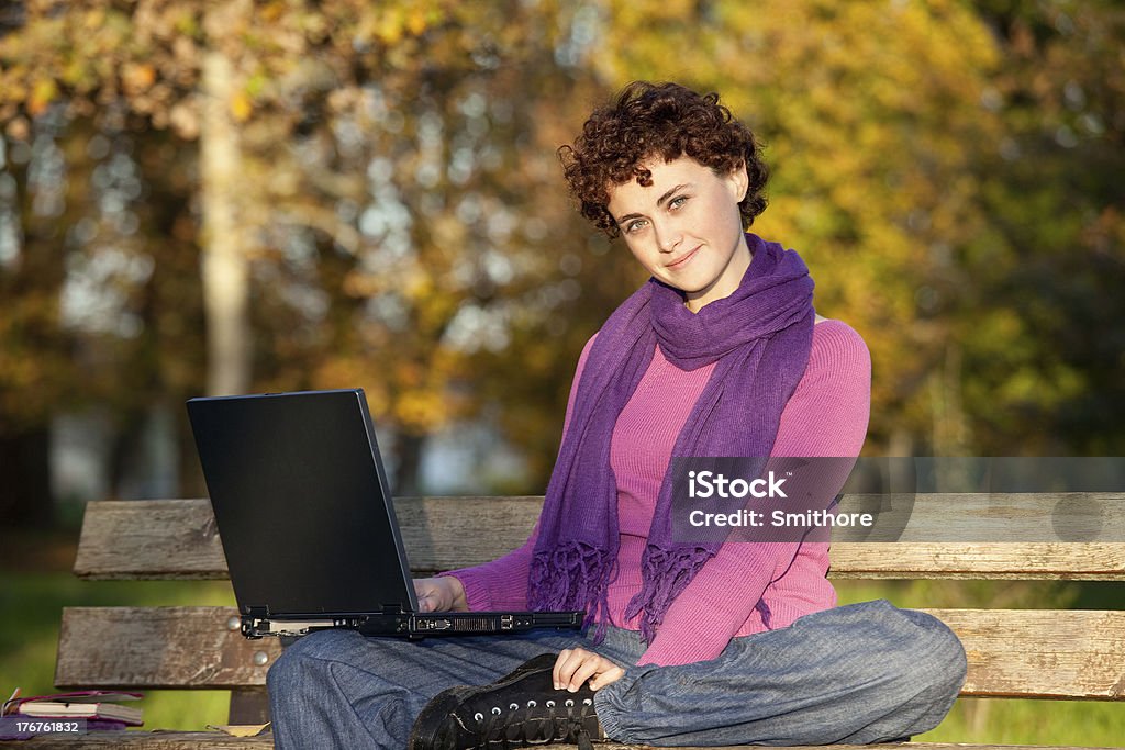 Kobieta z komputerem na park bench - Zbiór zdjęć royalty-free (Akcesorium osobiste)