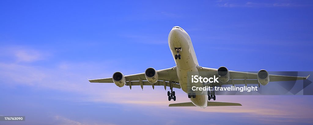 Getto velivolo di atterraggio con brillante cielo blu crepuscolo panoramica - Foto stock royalty-free di Aereo di linea