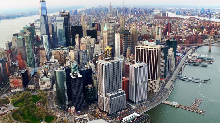 Aerial view of skyscrapers in Lower and Midtown Manhattan. Brooklyn and Manhattan Bridge in the background. Shot from a helicopter.