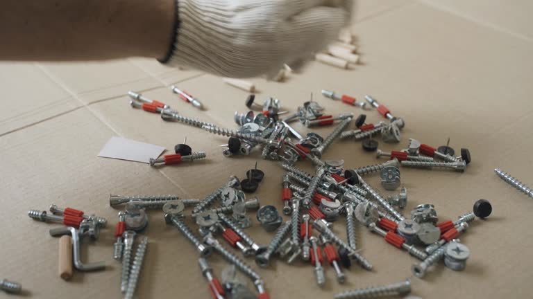 A worker checks furniture fasteners after unpacking.