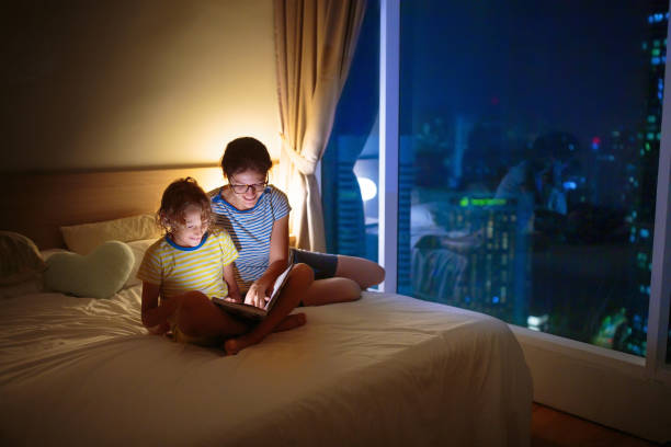 istock Child and mother read a book in dark room. 1767643519