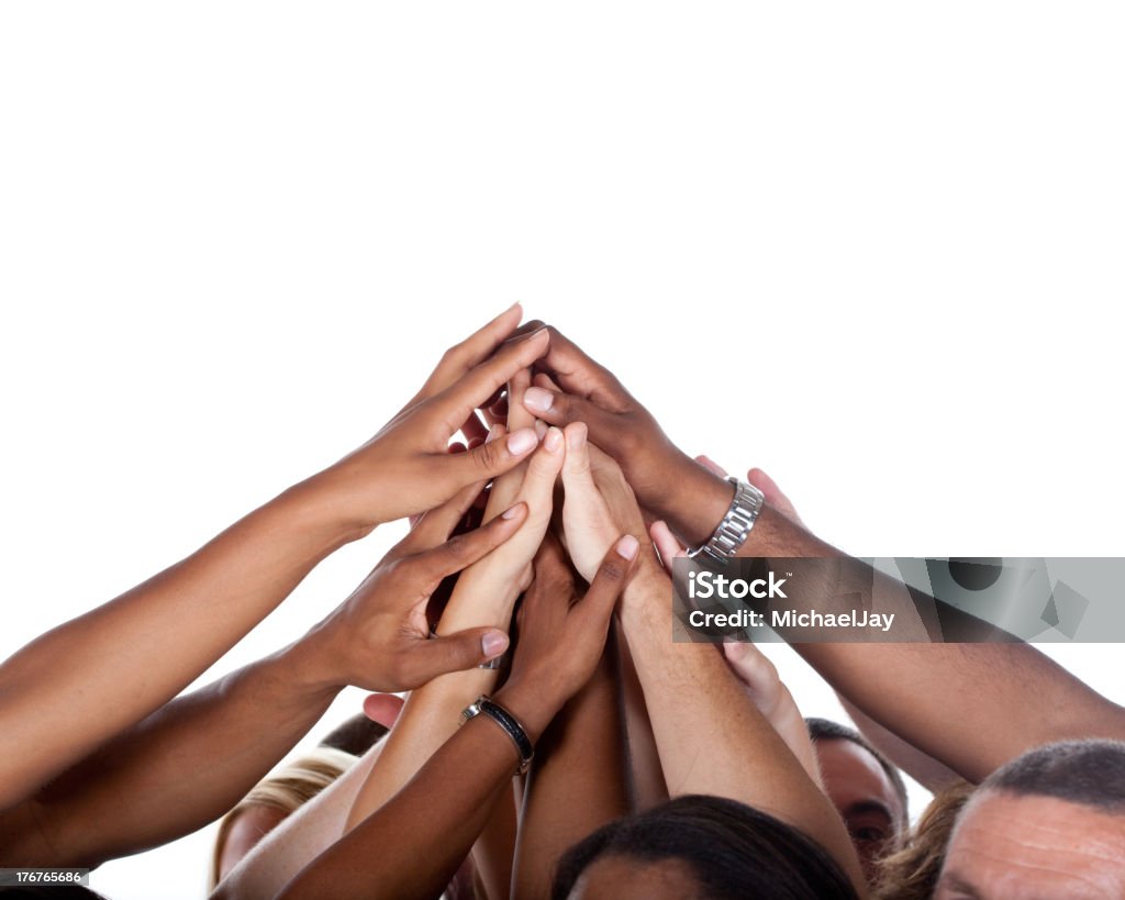 Multi-Ethnic Team Celebrating Large Group of people raising and joining their hands up high to celebrate their teamwork or success. Hand Raised Stock Photo