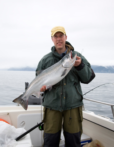 Proud fisherman with nice Alaskan silver (Coho) salmon