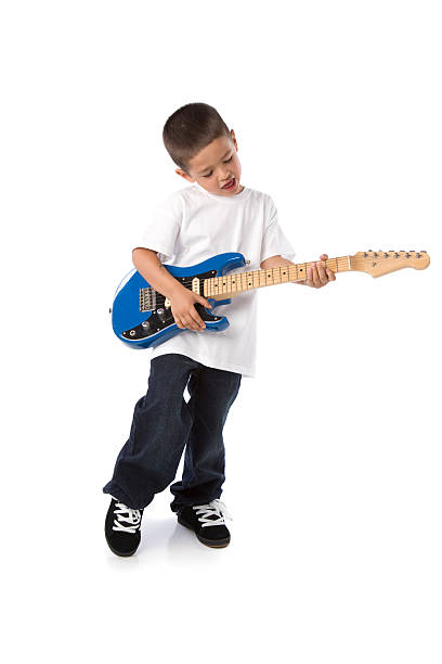 A little Hispanic boy sings and plays an electric guitar.