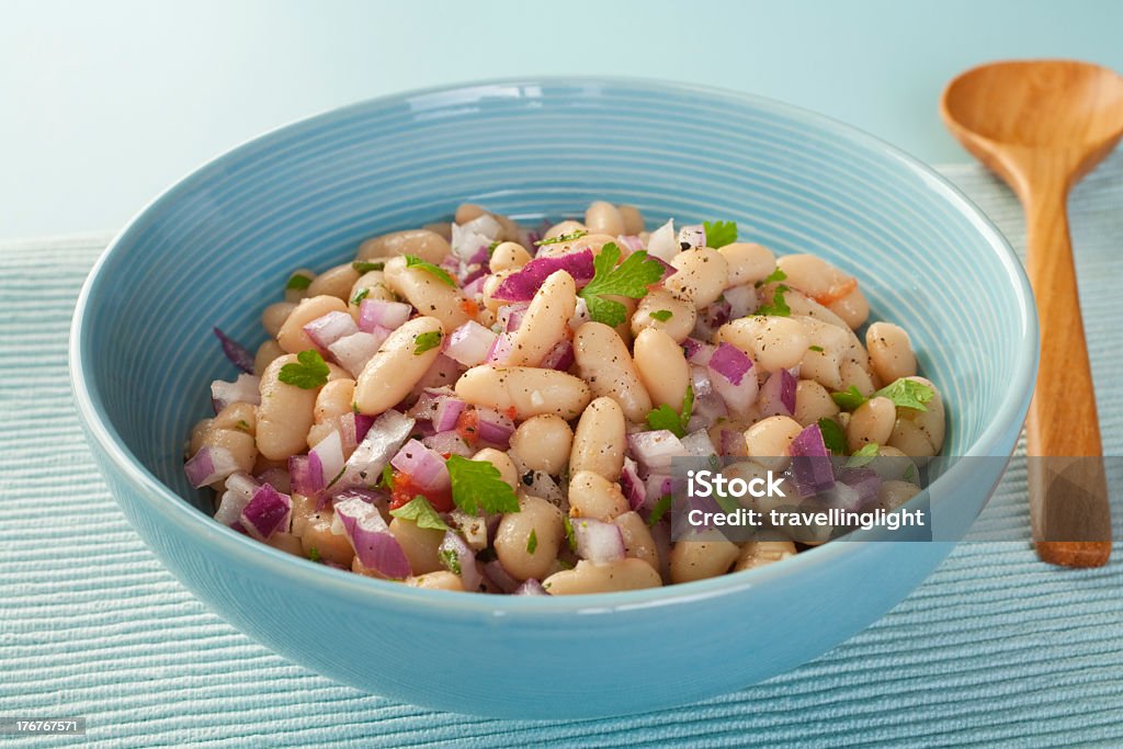 Bowl of fresh bean salad with purple onion Italian cannelini bean salad of beans in lemon vinaigrette with red onion, rosemary, parsley and garlic. White Bean Salad Stock Photo