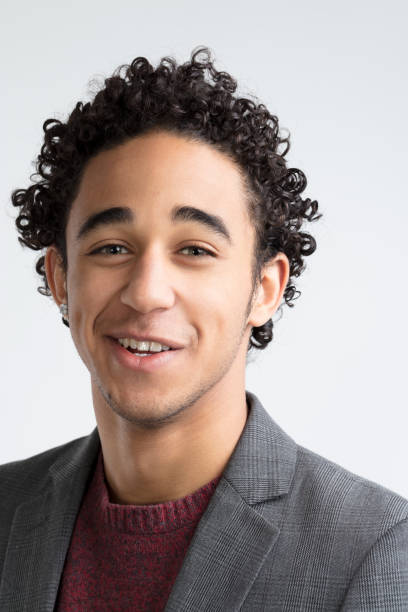 Curly-haired man radiates warmth, dressed fashionably