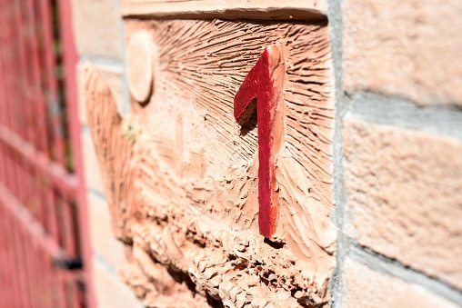 A red arrow is affixed to the side of a building, pointing outwards in an unknown direction