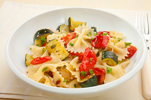 Close-up of bowtie pasta salad with zucchini, peppers stock photo