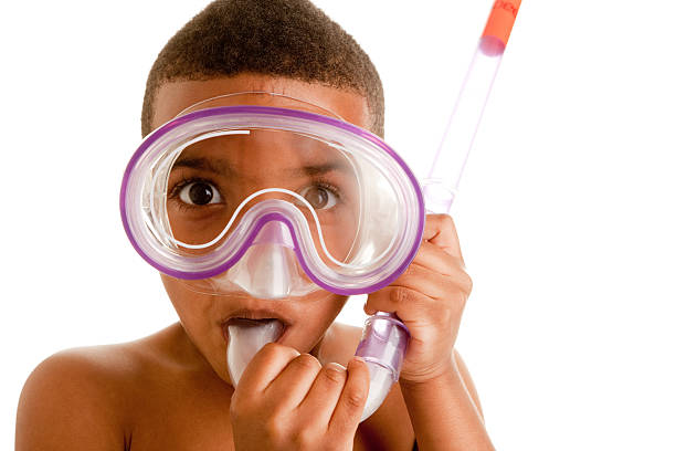 A black 5 year old boy gets ready for some summer fun with his snorkeling equipment.