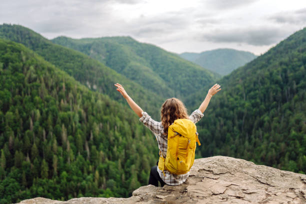 istock An active woman with a yellow backpack travels through the mountains. 1767686981