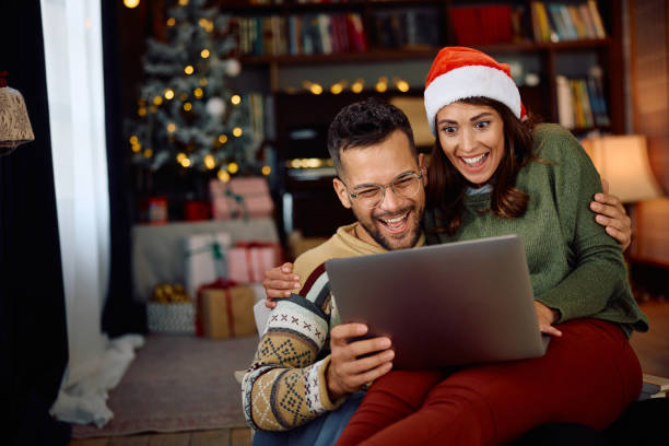 istock Cheerful couple having fun while making video call at Christmas at home. 1767687395