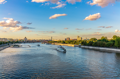 Cruise ship sails on the Moscow river in Moscow city center, popular place for walking. Panoramic view of Moscow river with cruise boat