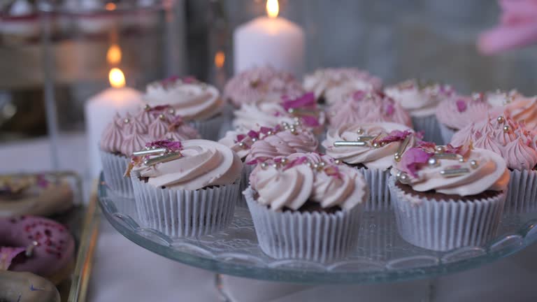 tasty cupcakes on decorated table, dolly backward movement, candles in background