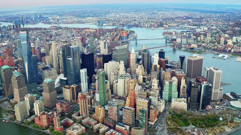 Aerial view of skyscrapers in Lower and Midtown Manhattan. Brooklyn and Manhattan Bridge in the background. Shot from a helicopter.