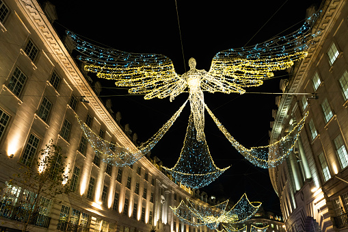 London, England, United Kingdom - December 17, 2022: Illuminated holiday lights and decor on Regents Street in the city during the Christmas season
